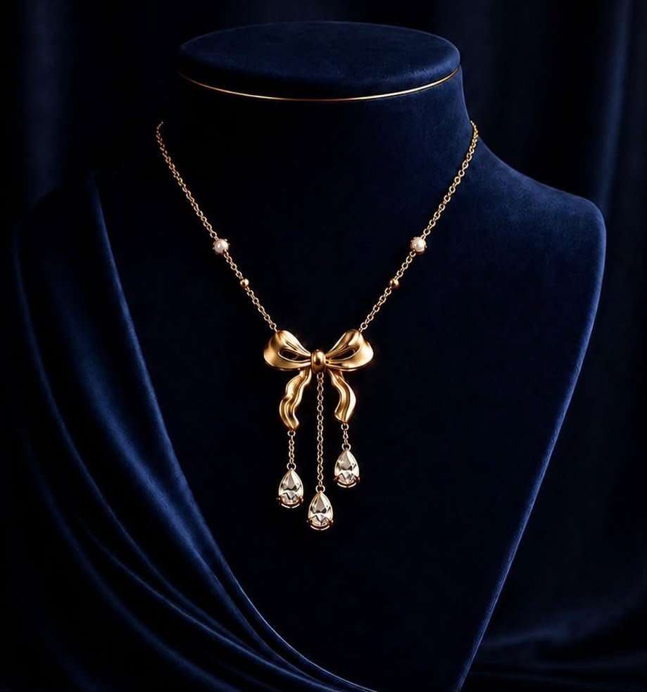 A delicate bow chain on midnight velvet.
