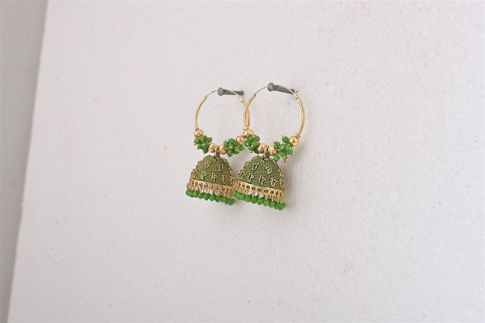 Green jhumkas with a playful traditional finish.